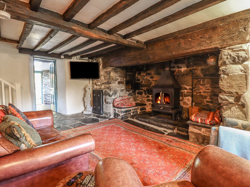 A living room with a fireplace and television at Y Cwtch Dolgellau