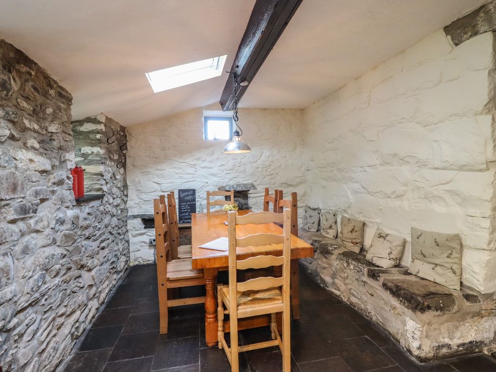 A dining room with a wooden table and chairs at Y Cwtch Dolgellau
