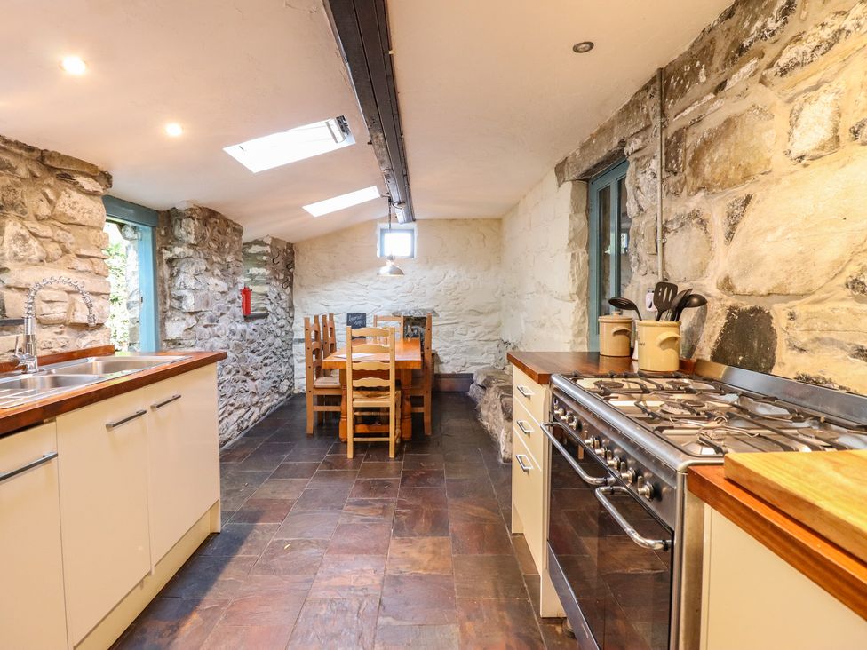 A kitchen with a dining table and chairs at Y Cwtch in Dolgellau