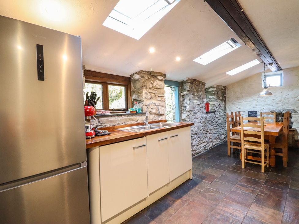 A kitchen with a refrigerator and dining table at Y Cwtch in Dolgellau