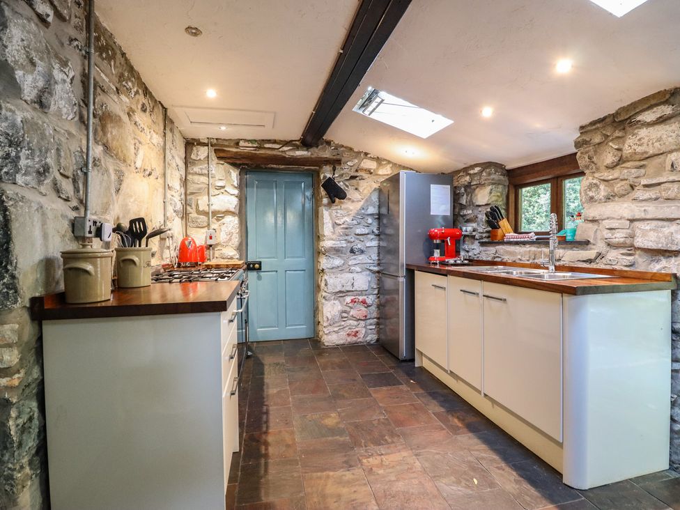 A kitchen with stone walls and modern appliances at Y Cwtch in Dolgellau
