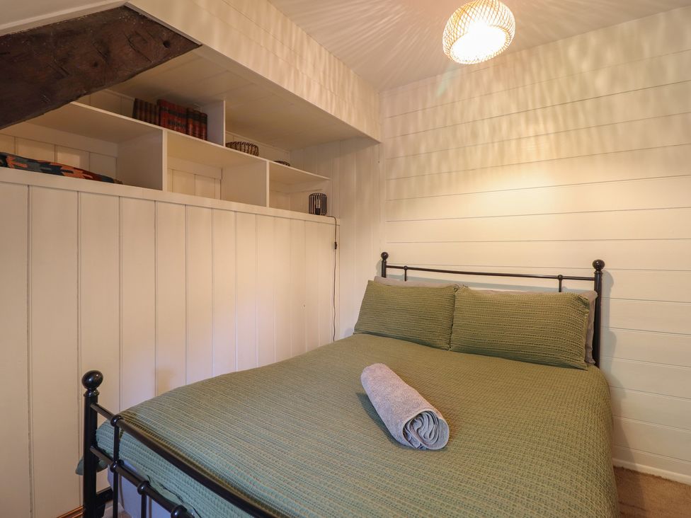 A bedroom with a bed and a bookshelf at Y Cwtch in Dolgellau