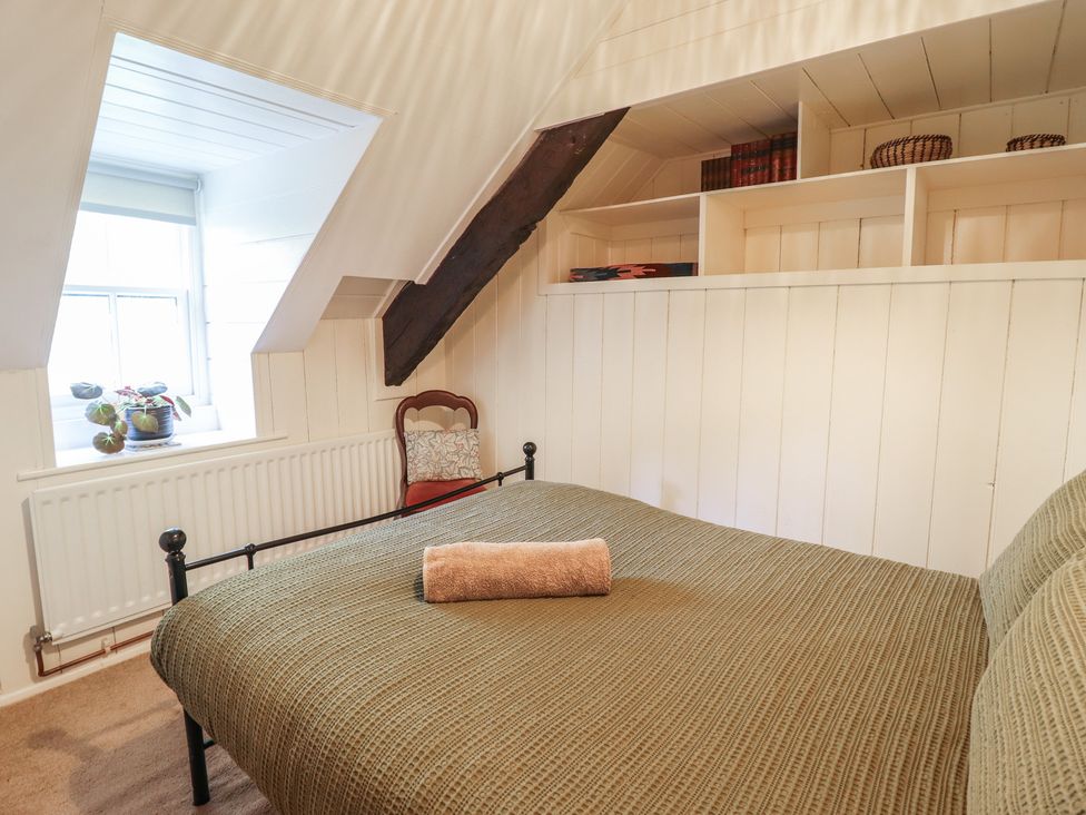 A bedroom with a bed and window at Y Cwtch in Dolgellau