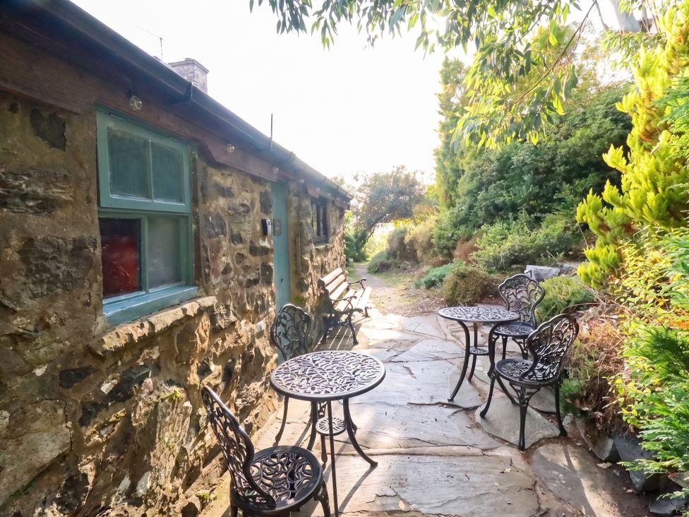 An outdoor seating area with tables and chairs at Y Cwtch Dolgellau