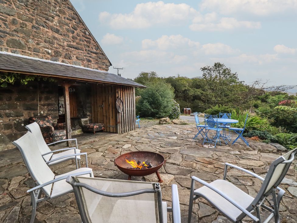 An outdoor area with a fire pit and chairs at Waen Fechan in Dolgellau