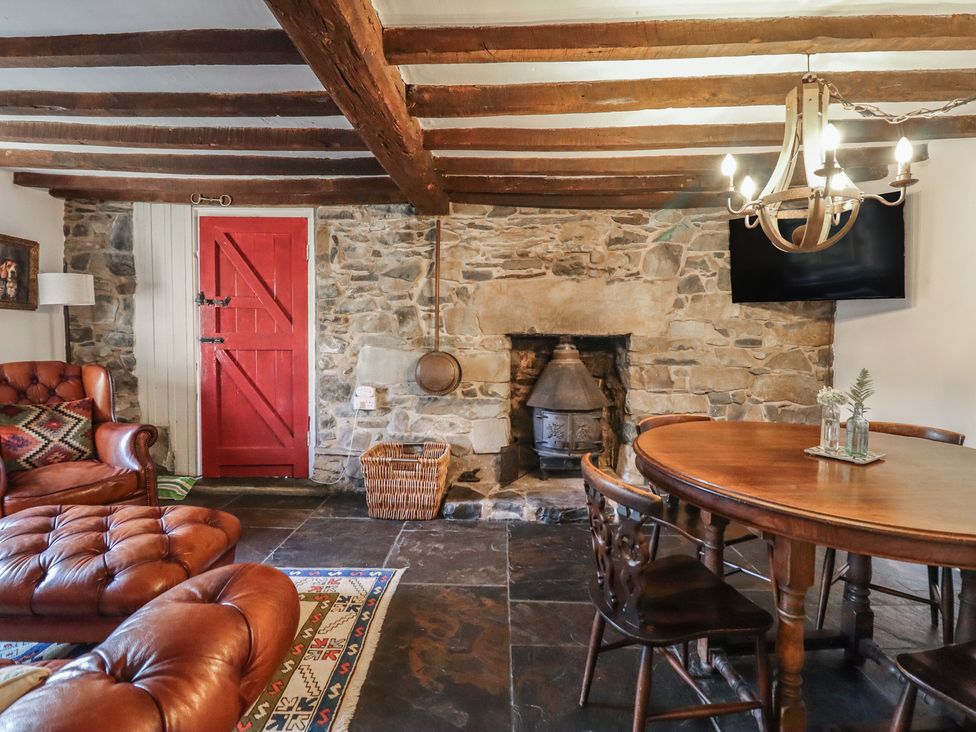 A living room with a sofa, table, chairs, and fireplace at Waen Fechan in Dolgellau