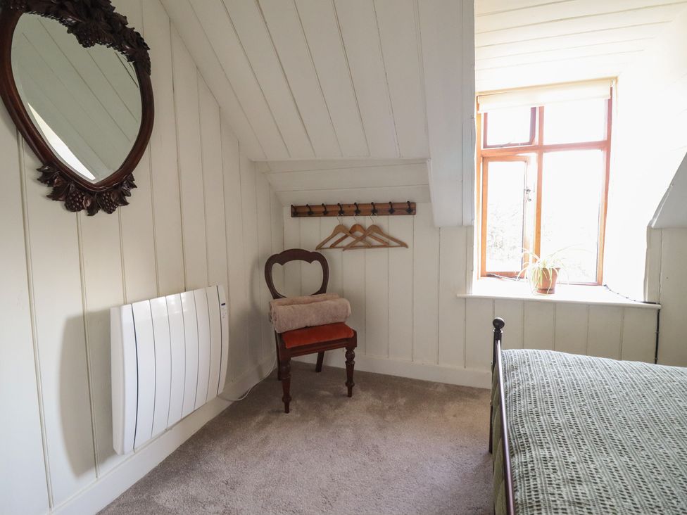 A bedroom with a chair and towel at Waen Fechan in Dolgellau
