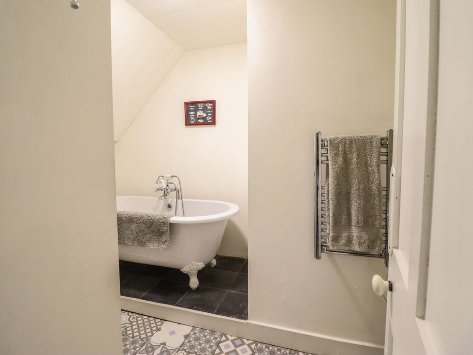 A bathroom with a bathtub and towel rack at Waen Fechan in Dolgellau