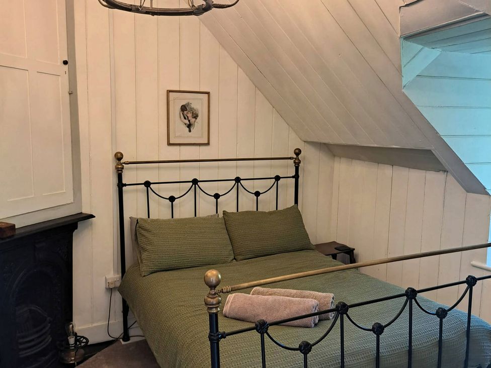 A bedroom with a bed and a painting at Waen Fechan in Dolgellau