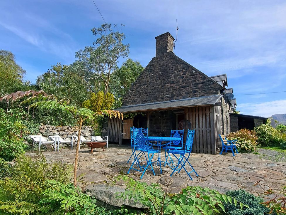A stone house with a patio, table and chairs at Waen Fechan in Dolgellau