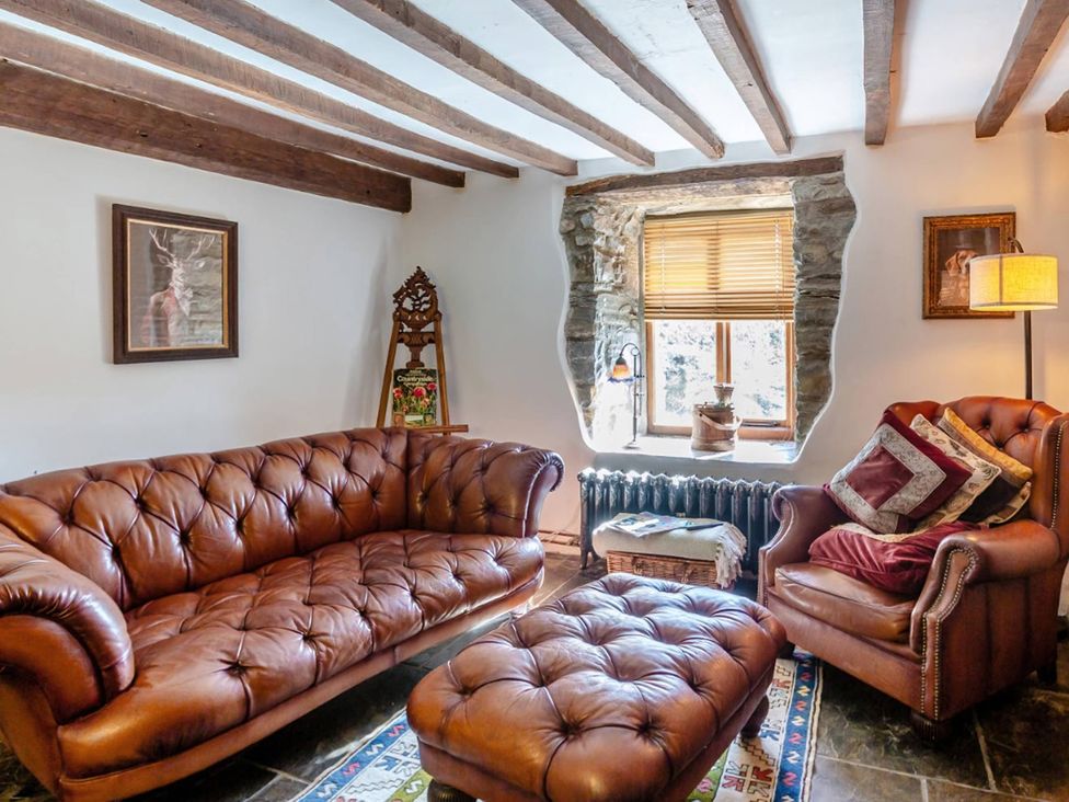 A living room with a leather sofa and armchair at Waen Fechan in Dolgellau