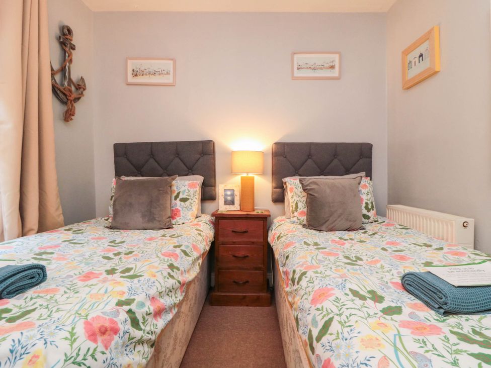 A bedroom with two beds and a nightstand at 1 St. Anns Lane, Whitby