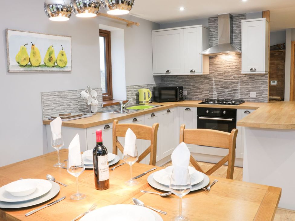 A kitchen with dining table and chairs at Woodman's Lodge Nantwich