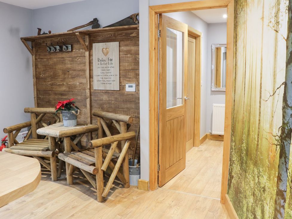 A hallway with wooden furniture and decorative wall at Woodman's Lodge in Nantwich