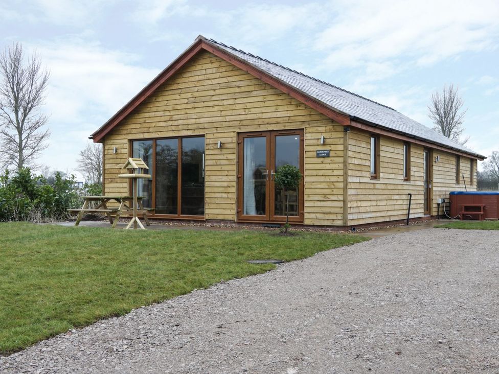 A house with windows and a patio at Gardener's Lodge in Nantwich