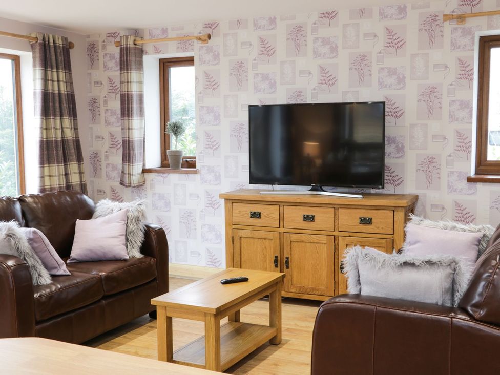 A living room with a sofa and a television at Gardener's Lodge in Nantwich