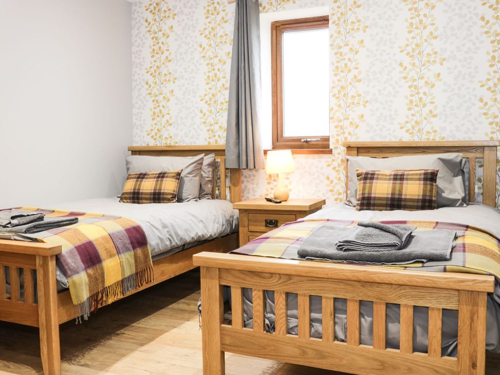 A bedroom with two beds and a window at Gardener's Lodge in Nantwich