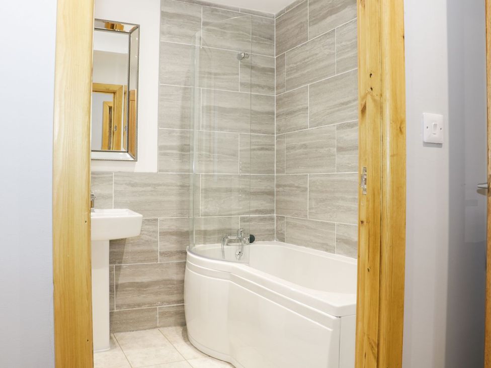 A bathroom with a bathtub and sink at Gardener's Lodge in Nantwich