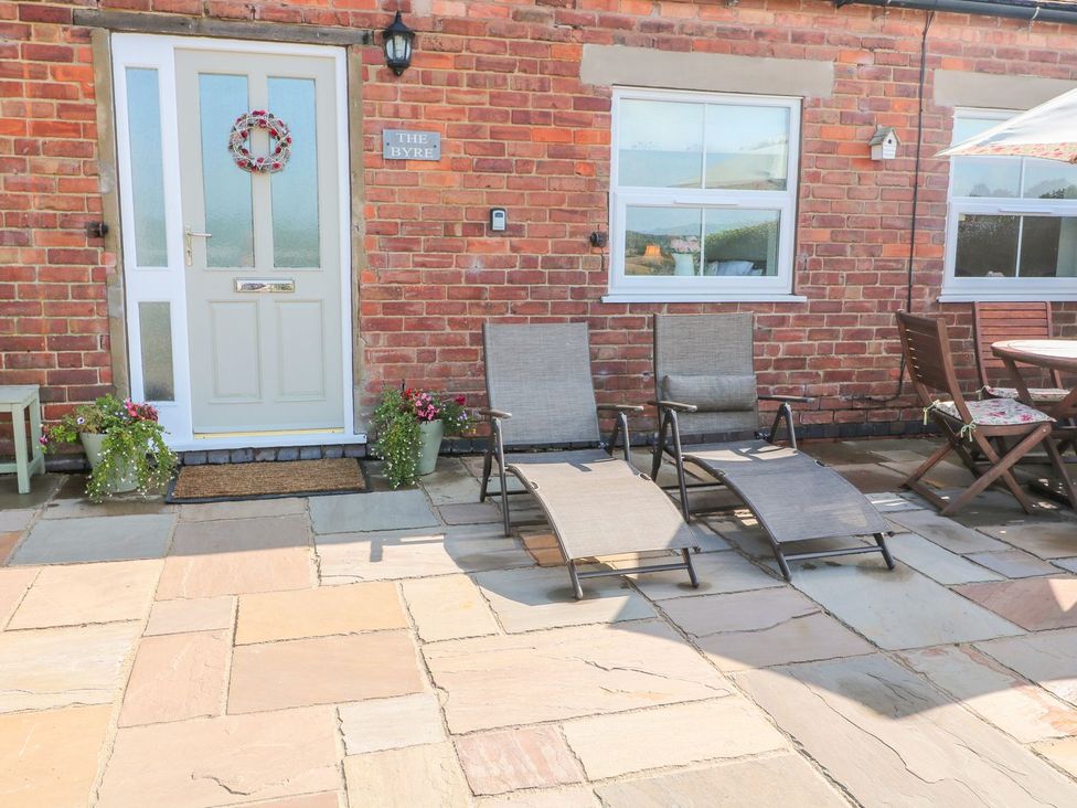 An outdoor space with chairs and a table at The Byre in Ashbourne