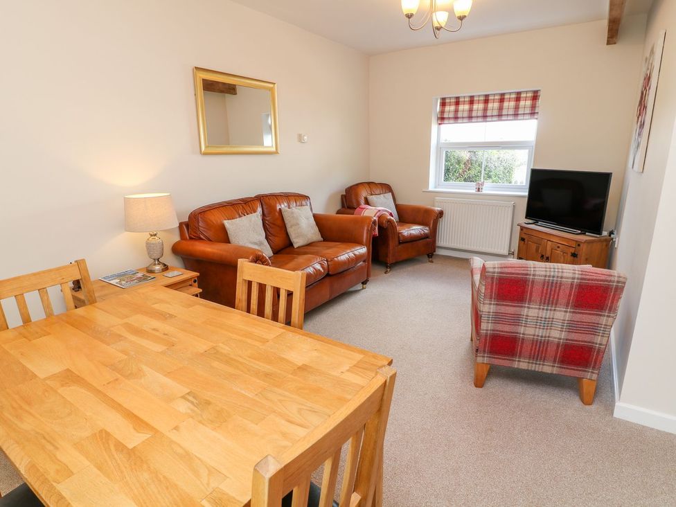 A living room with a television and sofa at The Byre in Ashbourne