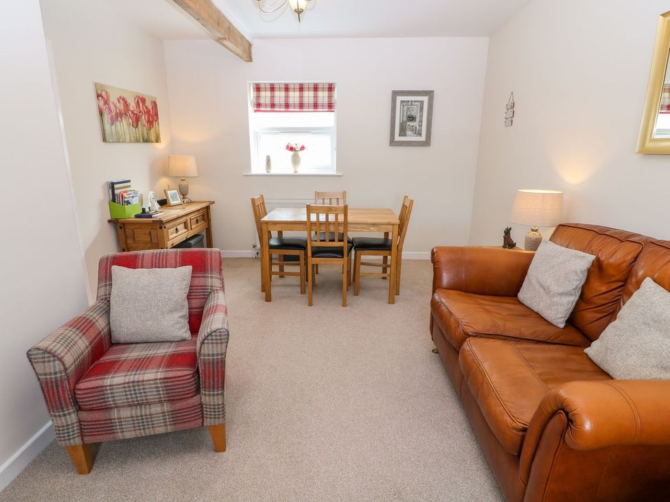A living room with a dining table and chairs at The Byre in Ashbourne