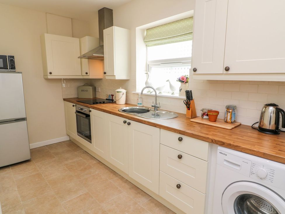 A kitchen with appliances and cabinets at The Byre in Ashbourne
