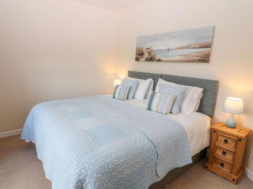 A bedroom with a bed and nightstand at The Byre in Ashbourne