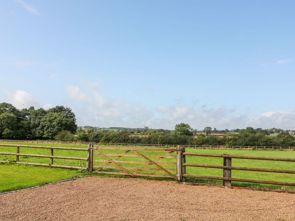 An outdoor area with a wooden gate and fence at The Byre in Ashbourne