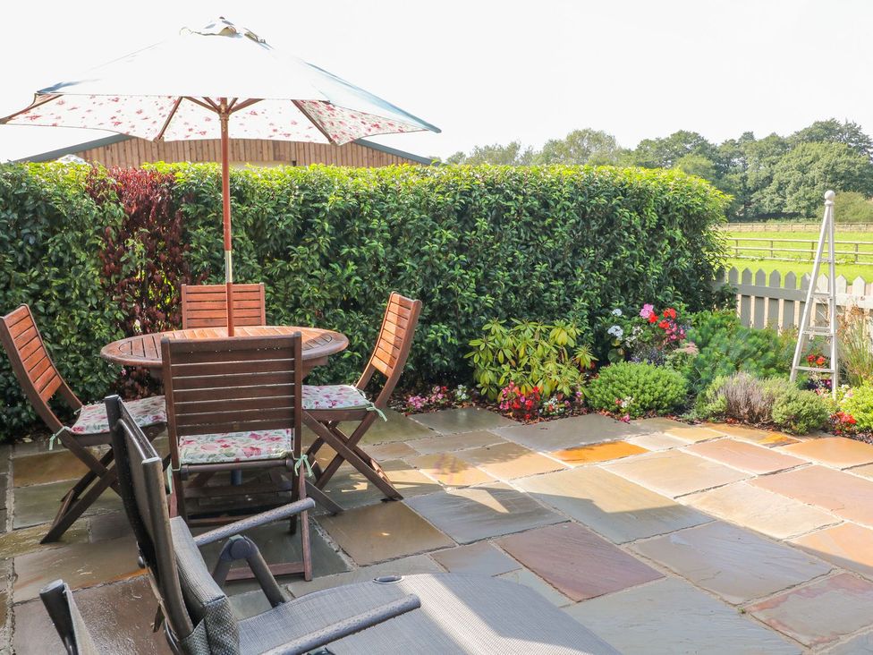 A garden patio with a table and chairs at The Byre Ashbourne