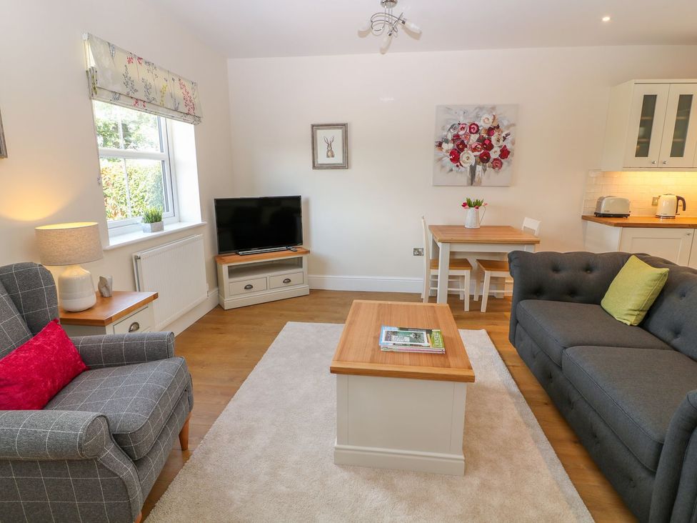 A living room with a sofa and television at The Croft in Ashbourne