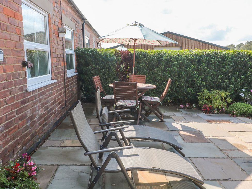 An outdoor seating area with a table and chairs at The Croft in Ashbourne