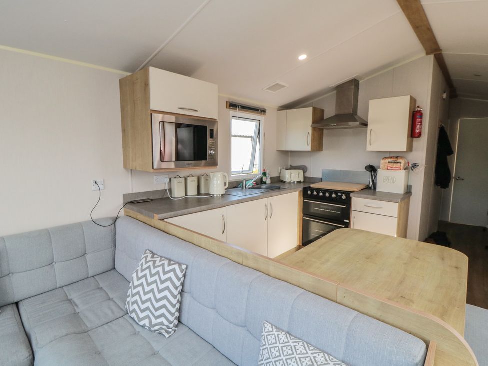 A kitchen with modern appliances and a sofa at 10 Gosling in Scarborough