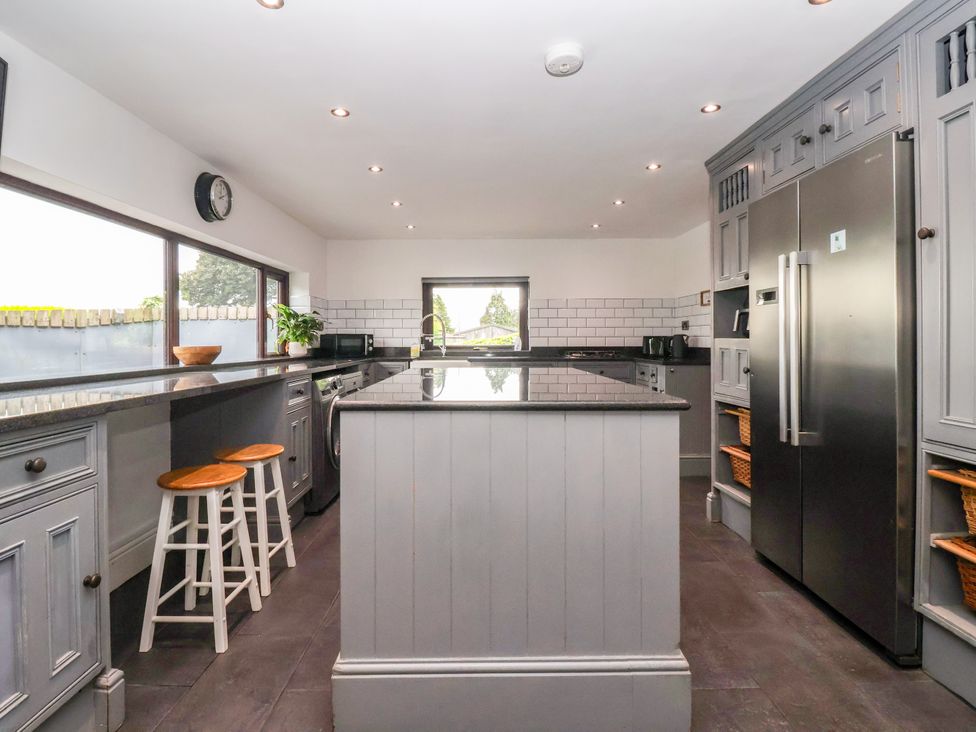 A kitchen with an island, refrigerator, and countertops at Brownhill Bungalow in West Morton near Riddlesden