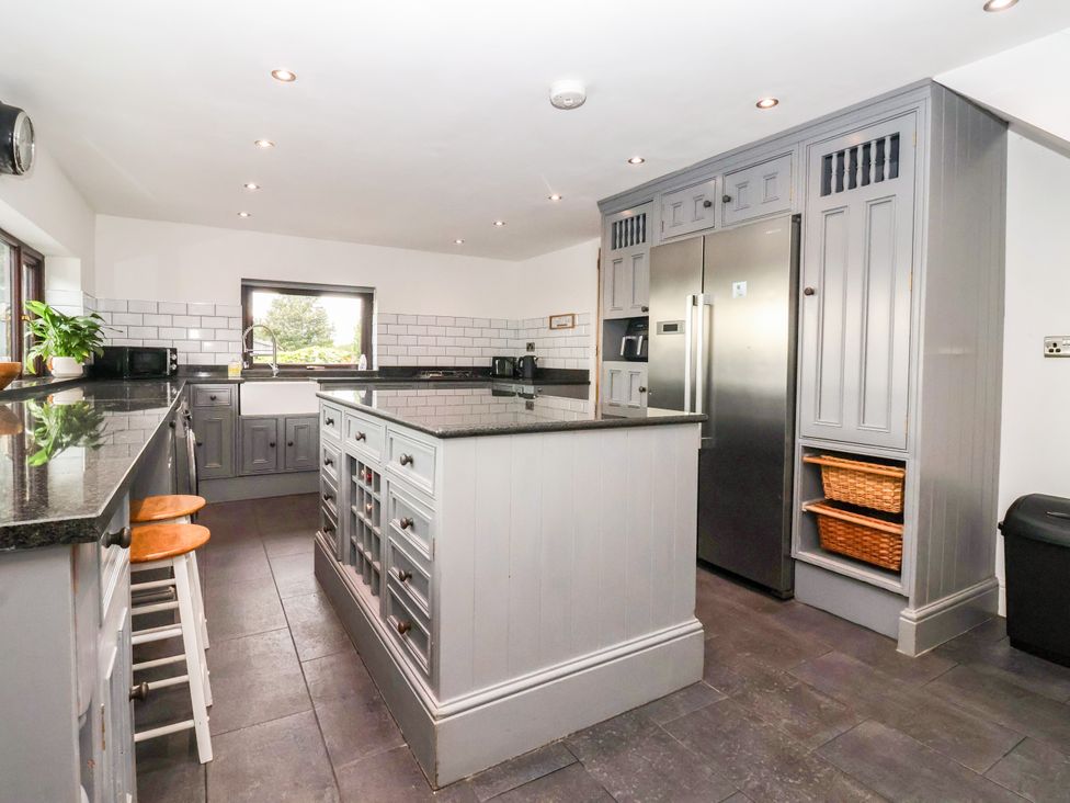 A kitchen with an island and refrigerator at Brownhill Bungalow in West Morton near Riddlesden