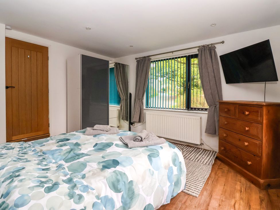 A bedroom with a bed and wardrobe at Brownhill Bungalow in West Morton near Riddlesden