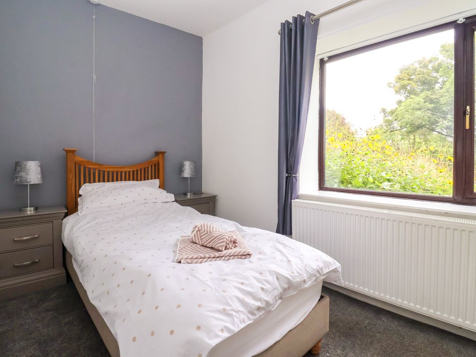 A bedroom with a single bed and a window at Brownhill Bungalow in West Morton near Riddlesden