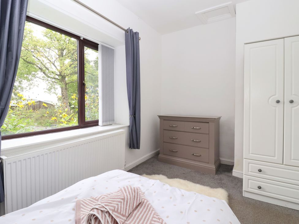 A bedroom with a window and furniture at Brownhill Bungalow in West Morton near Riddlesden