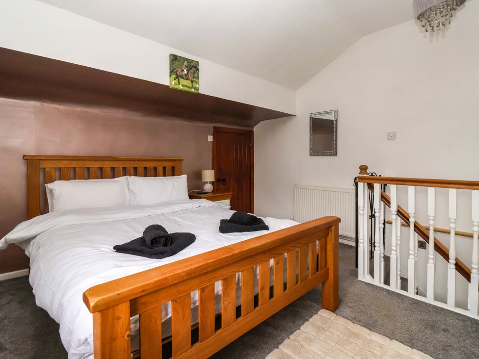 A bedroom with a bed and stairs at Brownhill Bungalow in West Morton near Riddlesden