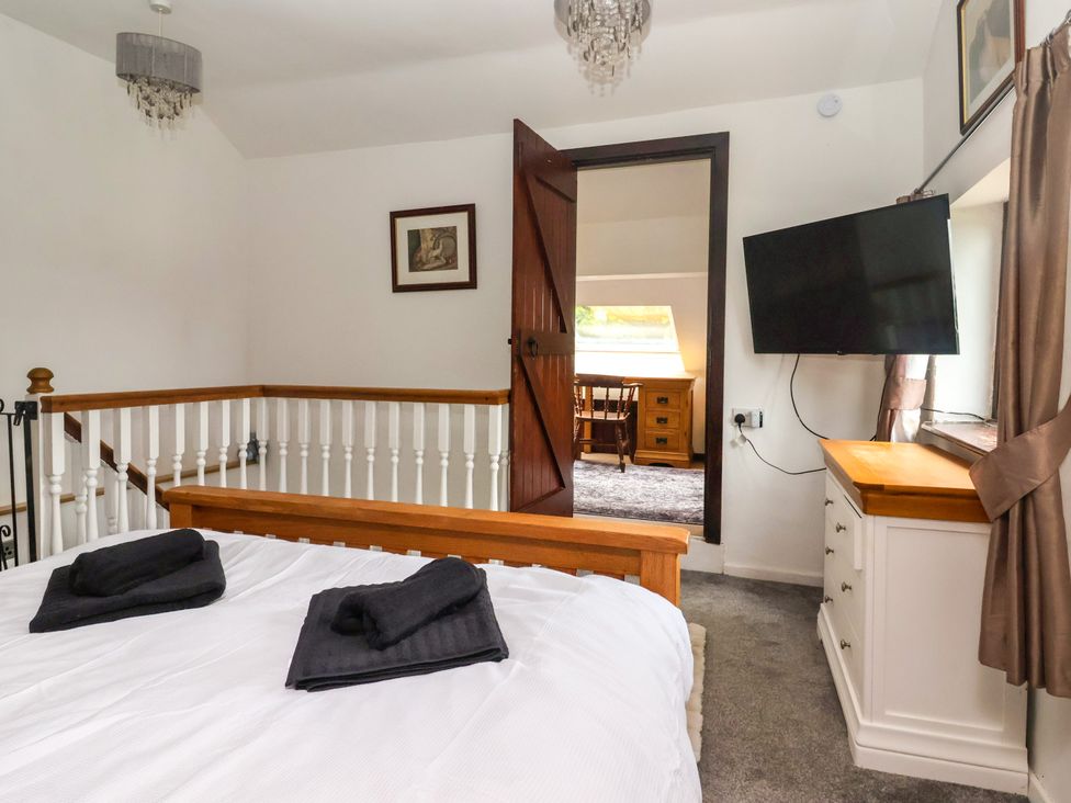 A bedroom with a bed and television at Brownhill Bungalow West Morton near Riddlesden