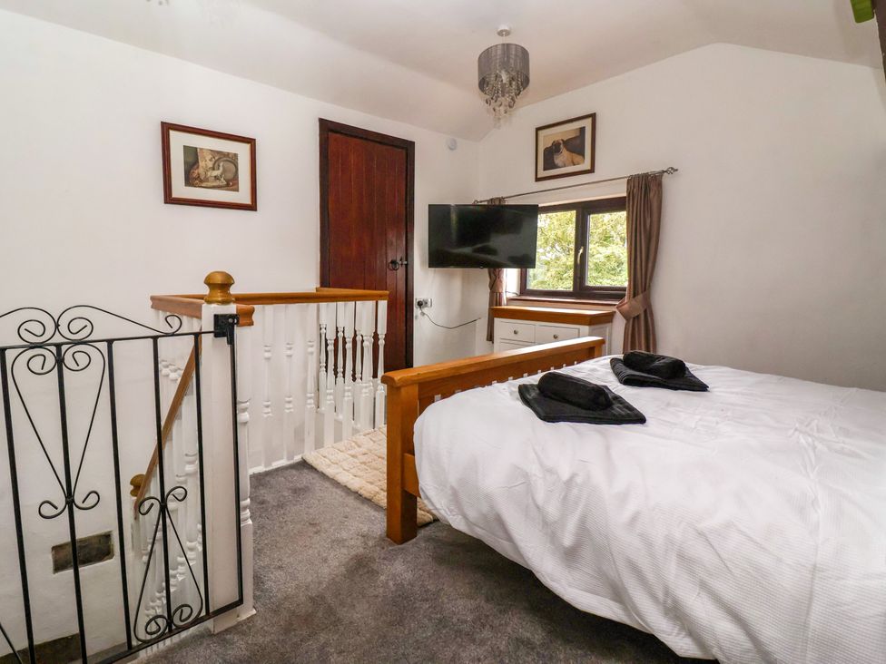 A bedroom with a bed and TV at Brownhill Bungalow in West Morton near Riddlesden