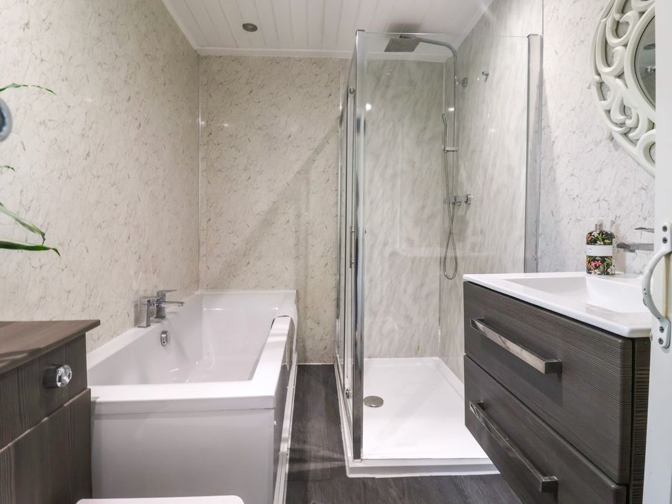 A bathroom with a bathtub and shower at Brownhill Bungalow in West Morton near Riddlesden