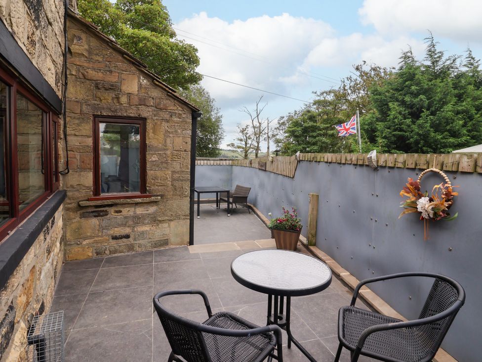 An outdoor patio with a table and chairs at Brownhill Bungalow in West Morton near Riddlesden