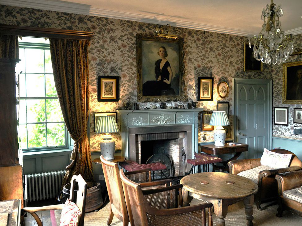 A sitting room with a fireplace and chairs at Wardhill Castle near Inverurie