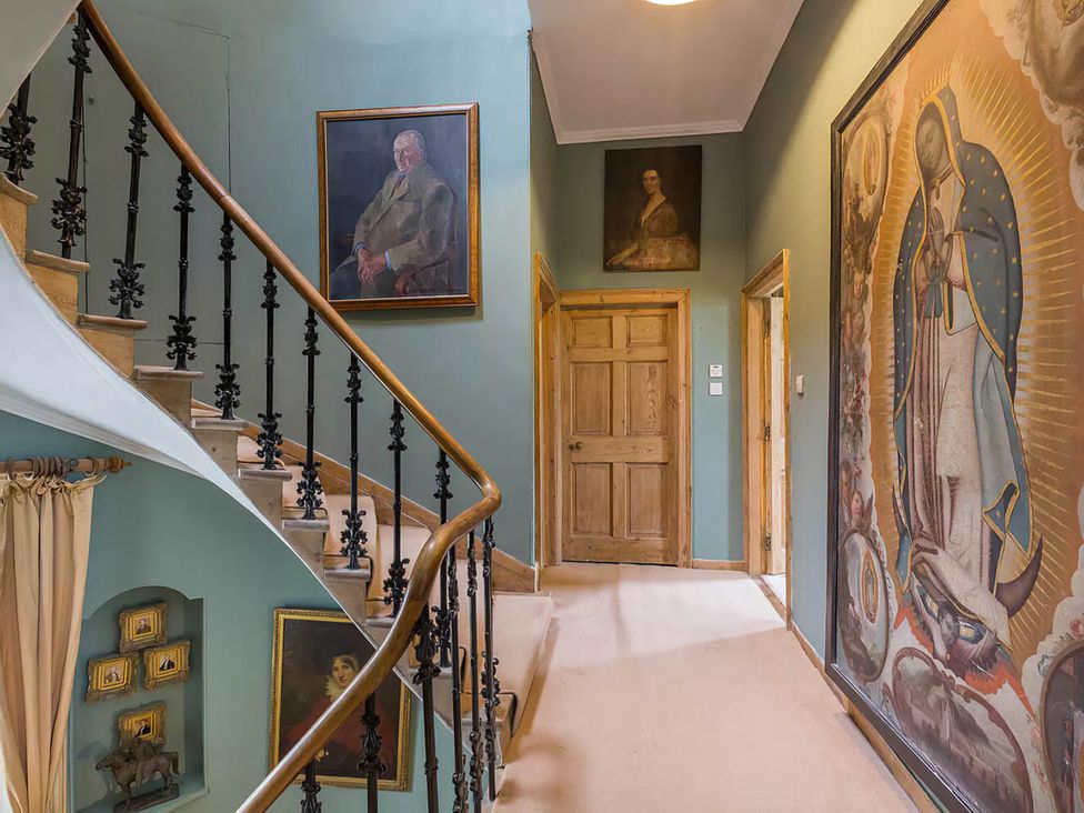 A staircase with paintings on the walls at Wardhill Castle near Inverurie