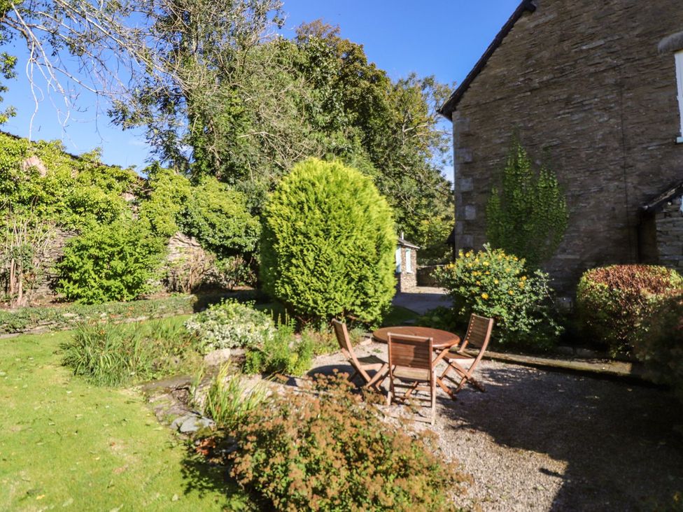 A garden with a table and chairs surrounded by greenery at Jessicas Cottage Windermere