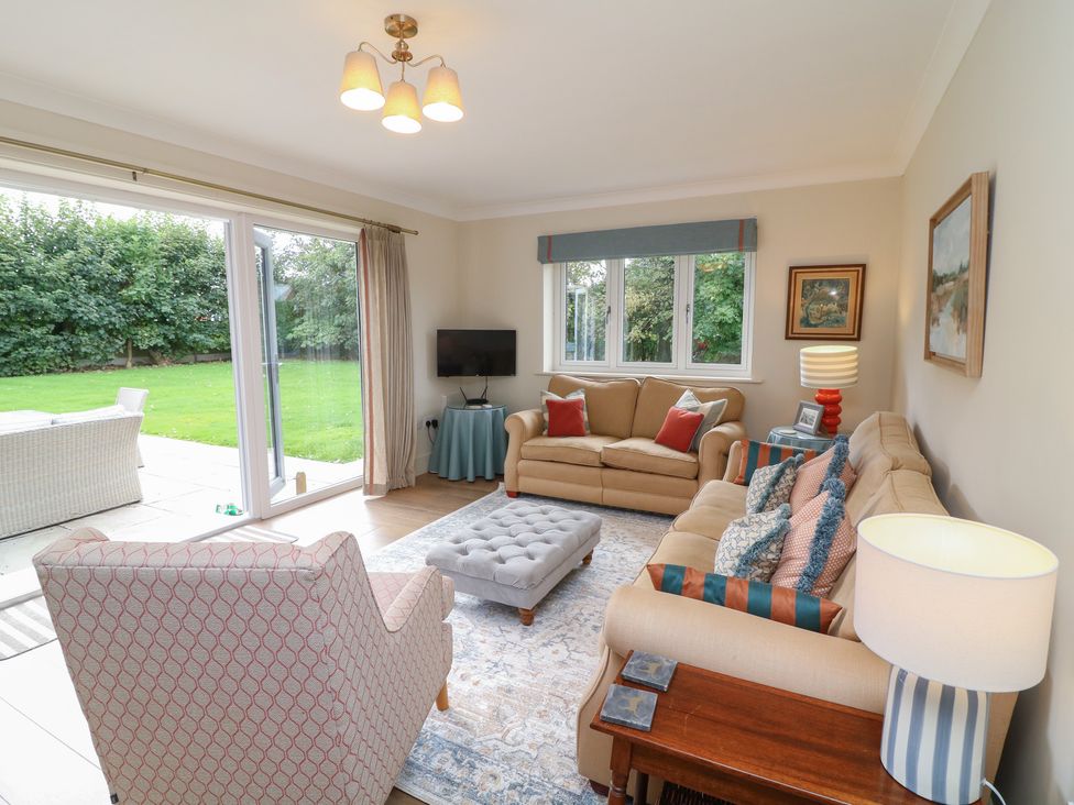 A living room with a sofa and sliding doors to the garden at The Willows in Mablethorpe