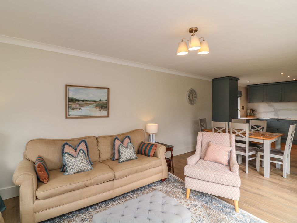 A living room with a sofa and dining area at The Willows in Mablethorpe