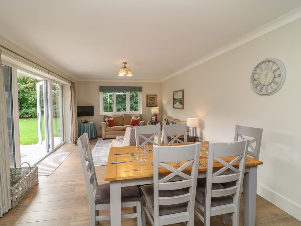 A dining area with a table and chairs next to a living space at The Willows in Mablethorpe