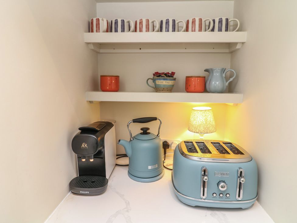 A kitchen corner with a coffee machine, kettle, toaster, and mugs at The Willows in Mablethorpe