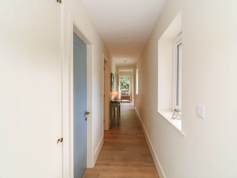 A hallway with doors and a table at The Willows in Mablethorpe